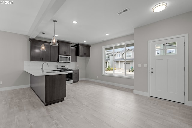 kitchen with kitchen peninsula, light hardwood / wood-style floors, appliances with stainless steel finishes, and hanging light fixtures