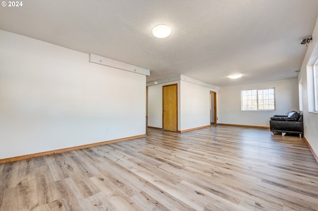 interior space with light wood-type flooring and a textured ceiling