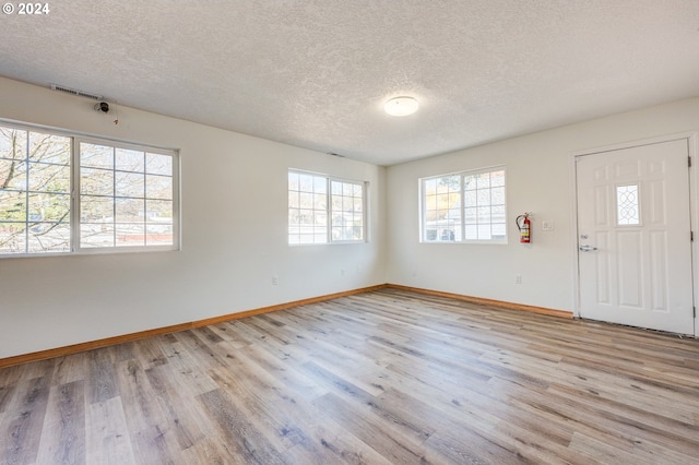 entrance foyer featuring light wood-type flooring and a textured ceiling