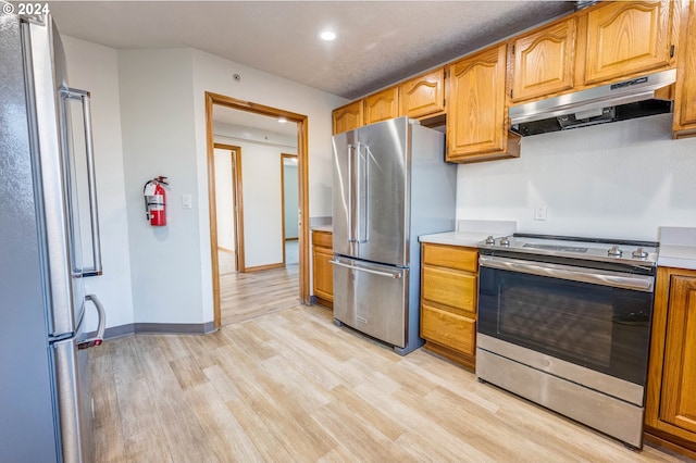 kitchen with light hardwood / wood-style flooring and appliances with stainless steel finishes