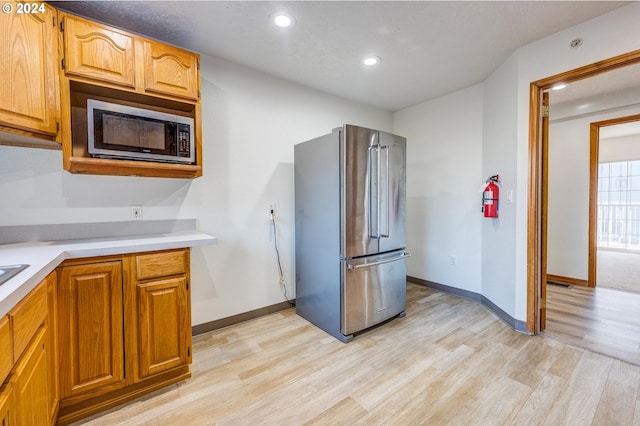 kitchen featuring appliances with stainless steel finishes and light hardwood / wood-style floors