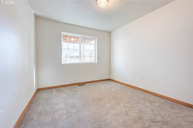 empty room with a textured ceiling and carpet