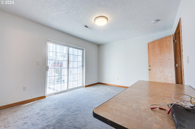 carpeted spare room featuring a textured ceiling