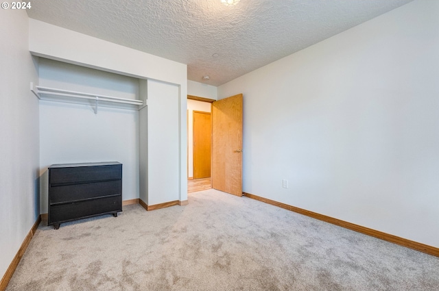 unfurnished bedroom with a closet, a textured ceiling, and carpet flooring