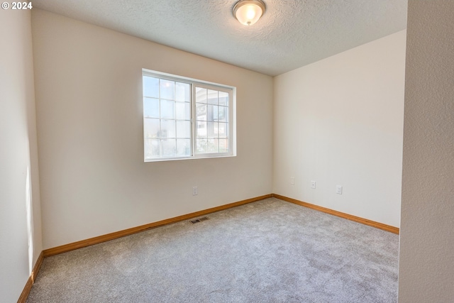 empty room featuring a textured ceiling and carpet flooring