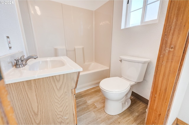 full bathroom featuring washtub / shower combination, wood-type flooring, toilet, and vanity