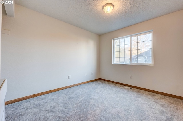 carpeted spare room featuring a textured ceiling