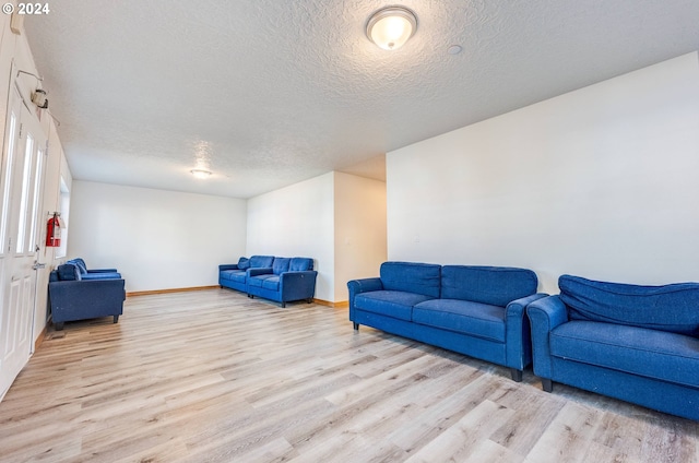 living room featuring a textured ceiling and light hardwood / wood-style flooring