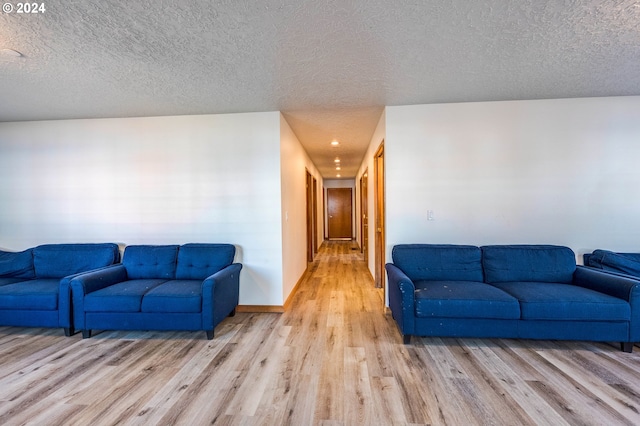 living room featuring light wood-type flooring and a textured ceiling