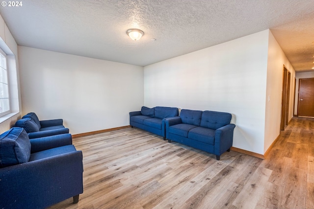 living room featuring light hardwood / wood-style floors and a textured ceiling