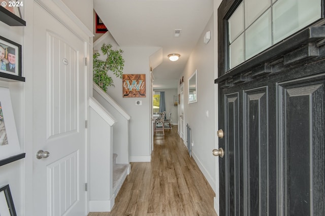 hallway with light hardwood / wood-style floors