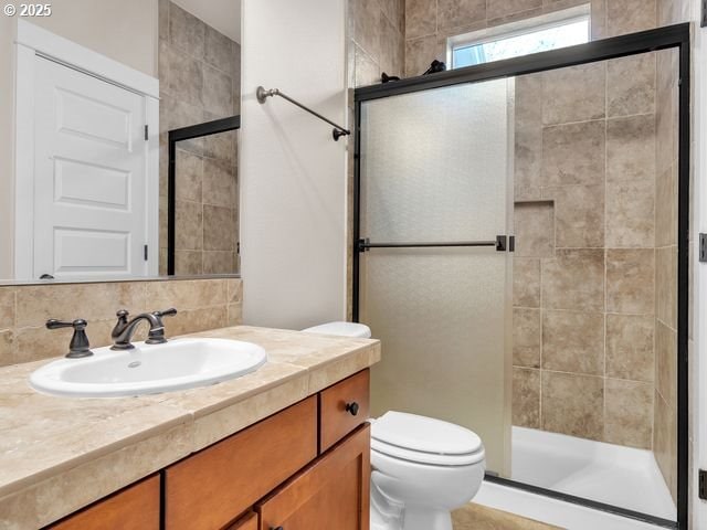 bathroom with toilet, a shower with door, tasteful backsplash, and vanity