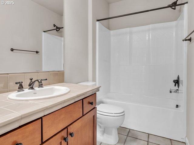 full bathroom with tub / shower combination, tile patterned floors, vanity, backsplash, and toilet