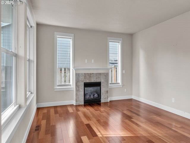 unfurnished living room with hardwood / wood-style floors and a fireplace