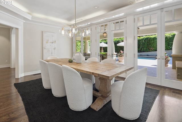 dining room featuring crown molding, dark hardwood / wood-style flooring, a chandelier, and french doors