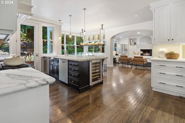 kitchen featuring light stone countertops, white cabinets, wine cooler, and dark wood-type flooring