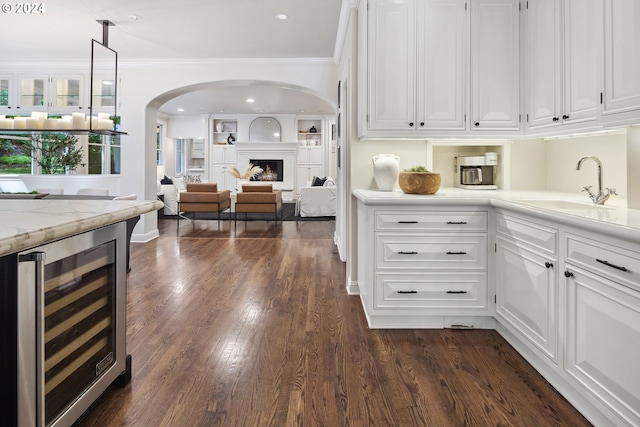 kitchen featuring white cabinetry, dark hardwood / wood-style flooring, crown molding, and wine cooler