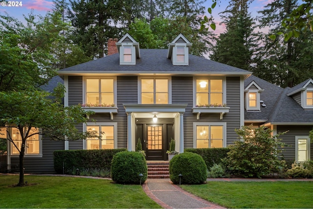 new england style home with a lawn