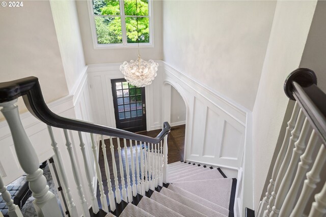 staircase featuring a notable chandelier