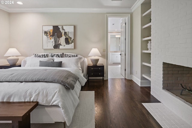 bedroom featuring crown molding, wood-type flooring, a brick fireplace, and ensuite bathroom