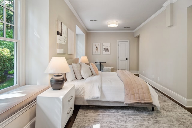 bedroom with dark wood-type flooring, crown molding, and multiple windows