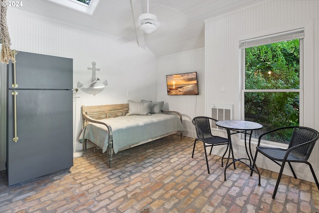 bedroom featuring black refrigerator and a skylight