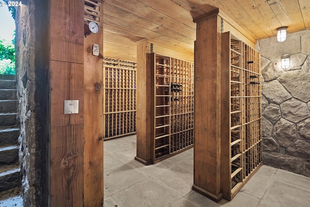 wine area featuring light tile patterned flooring and wooden ceiling