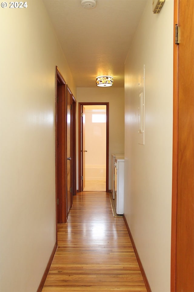 hallway with washing machine and dryer and light hardwood / wood-style floors