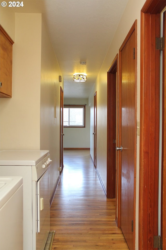 hallway featuring washer and dryer and light hardwood / wood-style flooring