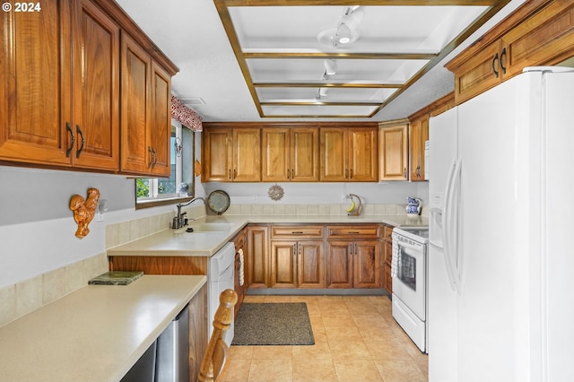 kitchen with white appliances, sink, and light tile patterned floors