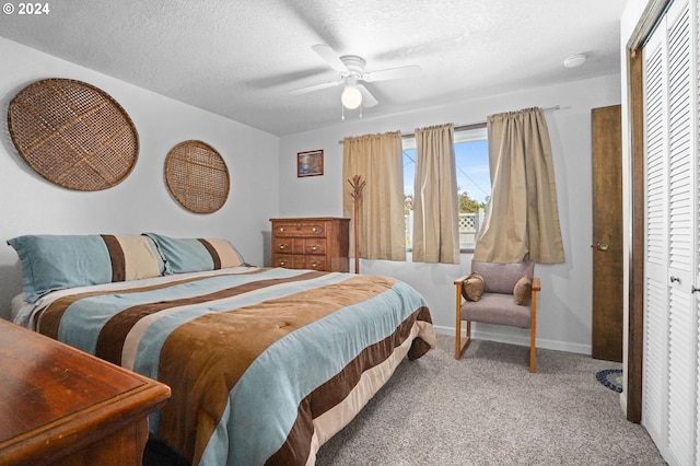 carpeted bedroom with a textured ceiling, a closet, and ceiling fan