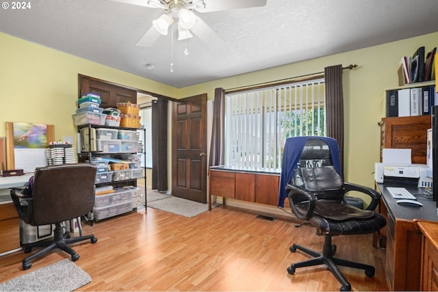 office space with a textured ceiling, light wood-type flooring, and ceiling fan