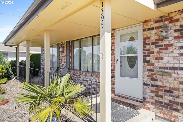 view of exterior entry featuring covered porch