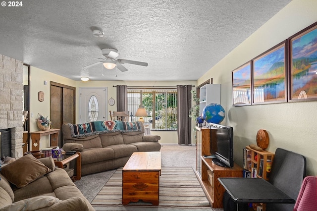 carpeted living room with a stone fireplace and ceiling fan