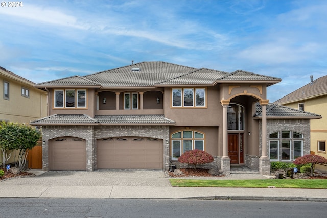 view of front of house featuring a garage, stucco siding, concrete driveway, and a tiled roof