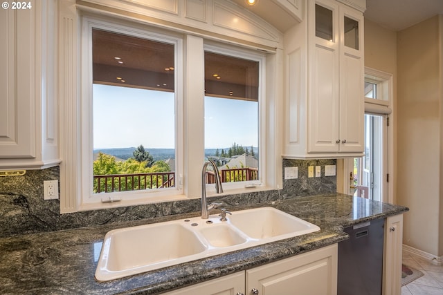 kitchen with tasteful backsplash, glass insert cabinets, white cabinets, a sink, and dishwashing machine