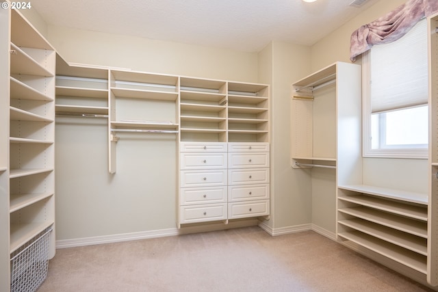 walk in closet featuring light carpet and visible vents