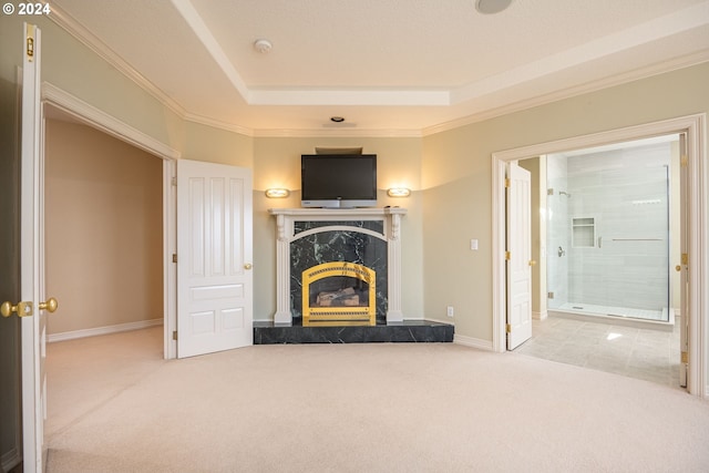 unfurnished living room featuring carpet floors, a raised ceiling, and crown molding