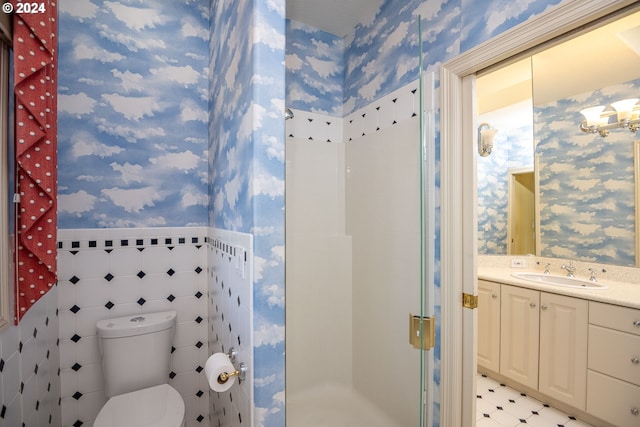 bathroom with wallpapered walls, a stall shower, toilet, a wainscoted wall, and tile walls