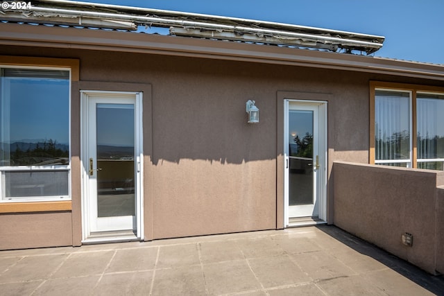 property entrance featuring a patio and stucco siding