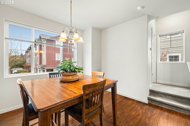 dining room with dark hardwood / wood-style floors and a chandelier