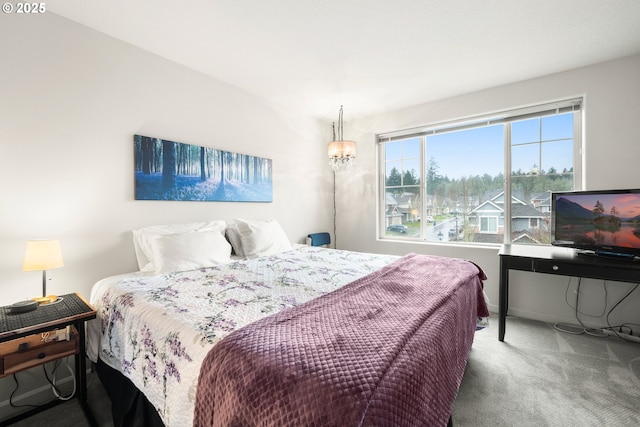 carpeted bedroom featuring an inviting chandelier