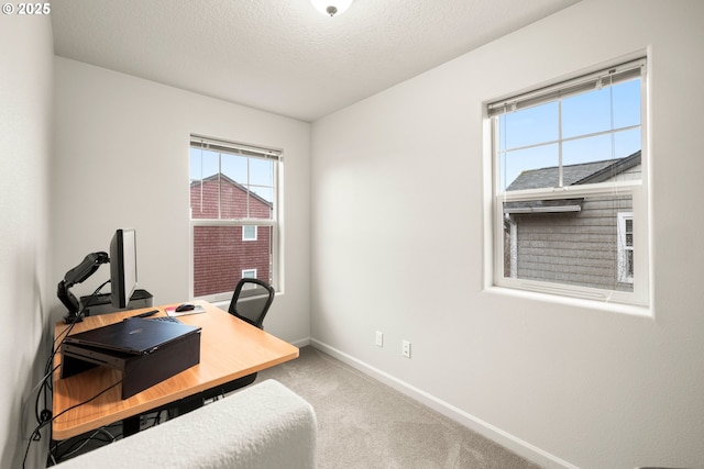 carpeted office space featuring a wealth of natural light and a textured ceiling