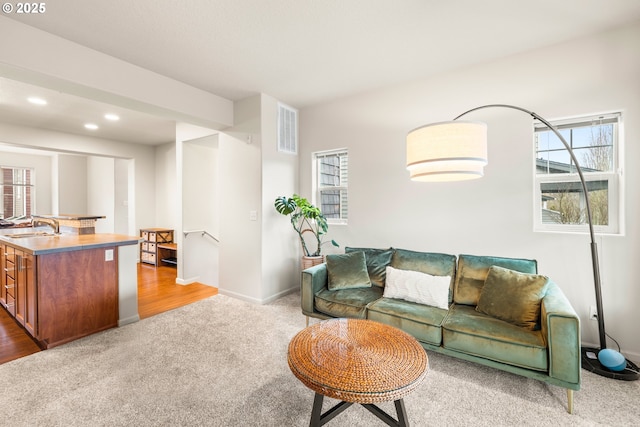 carpeted living room featuring sink