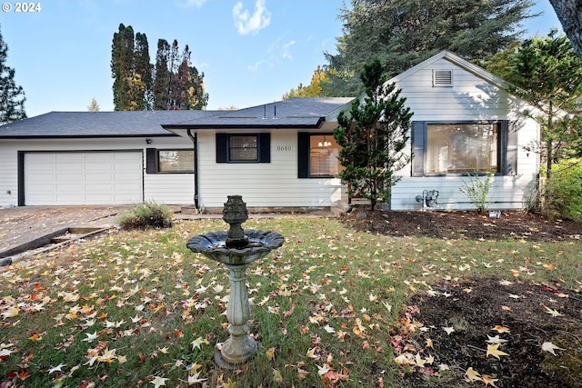 view of front of house featuring a garage and a front lawn