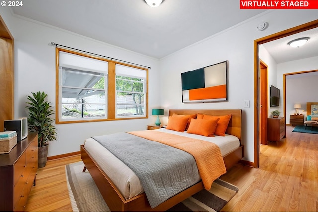 bedroom with light hardwood / wood-style flooring and ornamental molding