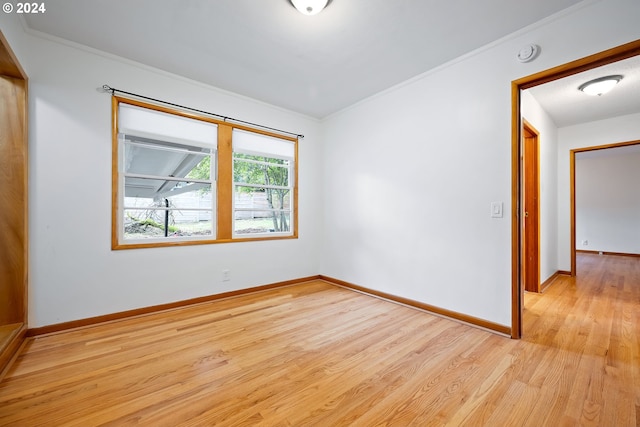 empty room featuring light hardwood / wood-style floors and crown molding