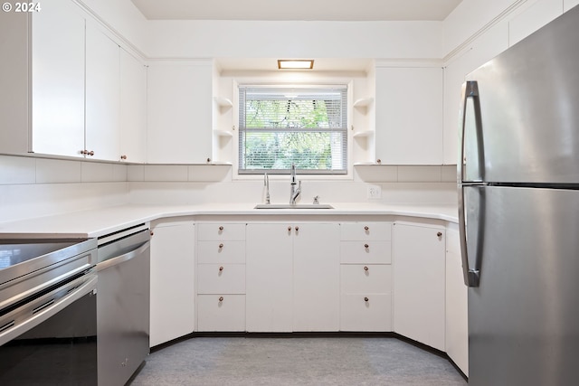 kitchen with white cabinetry, backsplash, appliances with stainless steel finishes, and sink