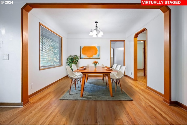 dining room with light hardwood / wood-style flooring and a chandelier