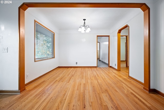 unfurnished dining area featuring light hardwood / wood-style flooring and an inviting chandelier